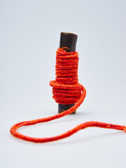 Orange Yarn Wrapped Around a Stick Against a Light Background