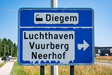 Fototapeta premium Road sign to the airport, Buurberg, Neerhof and industrial zone of Diegem Machelen, Flanders, Belgium
