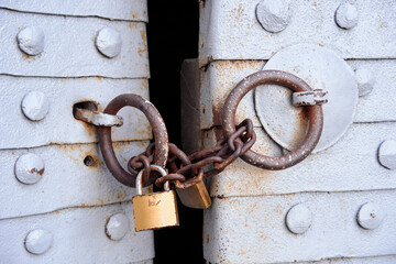 Rustic Chains and Padlock Securing a Weathered Metal Door Surface