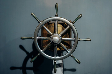 Antique Ship Wheel Displayed Against a Plain Background