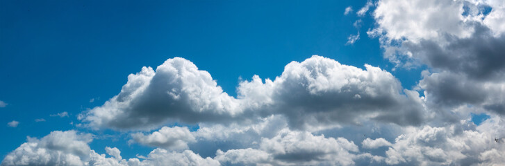 blue sky with fluffy white clouds, wide panorama