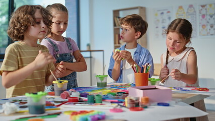 Naklejka premium Children working art workshop using colorful materials on school desk closeup. 