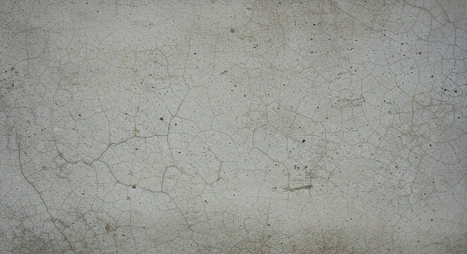 A close up of a gray concrete wall with cracks and small imperfections across the entire surface area