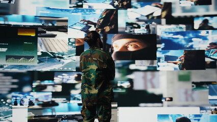 Military personnel monitoring drone and satellite imagery to gather data, finding enemy position helpful for war planning. Supporting national defense mission and secure global operations. Camera B.