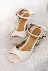 Bridal ivory shoes with bow and rhinestone tiara on soft white fabric