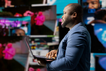 Black social media manager engaging with social network trends on screens, showcasing user...