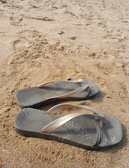Flip flops on sandy beach at sunrise with spa   ce for copy