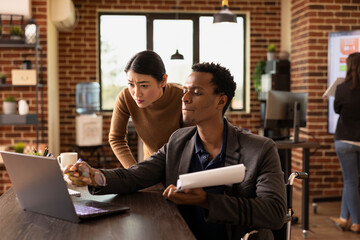 Employees working together in office, analyzing data charts and business reports. Asian woman and...