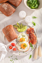 British and homemade breakfast with buns, fried eggs and chive.