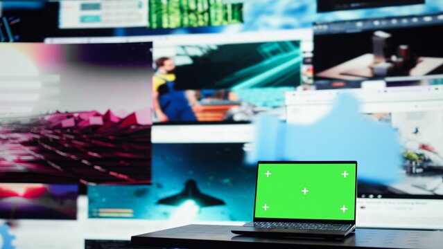 Green screen laptop in front of endless grid of streaming windows displaying mixed media. Mockup notebook and digital interface showing video platform distributing content to global viewers
