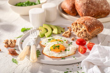 British and homemade breakfast with egg, tomato and rolls.