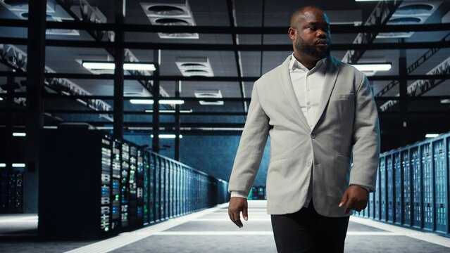 Admin working in high tech server hub capable of processing and storing vast amounts of data. African american IT specialist troubleshooting server rows controlling network resources, camera A - Powered by Adobe