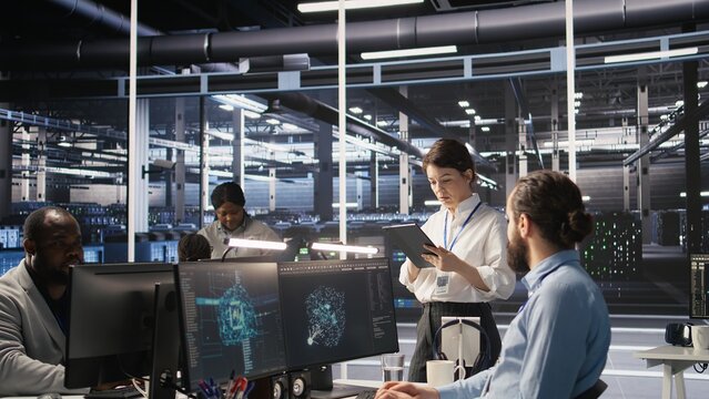 Data center team leader supervising system operations supporting neural networks and analytics workflows. Server hub manager monitoring engineering team managing AI training datasets, camera A