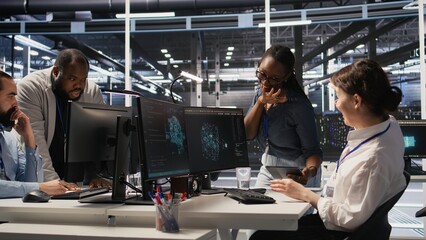Smiling technicians doing fist bump in data center after successful deployment of AI tools. Server room engineering team celebrate completion of machine learning system integration, camera A