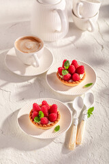 Sweet and delicious mini tart made of cream and raspberries.