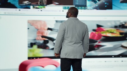 Joyous man using phone, receiving personalized video recommendations delivered instantly. Upbeat...