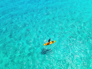 Aerial View of Kayaking canoe boat in Crystal Clear Turquoise Tropical Waters with Vibrant Blue Sea