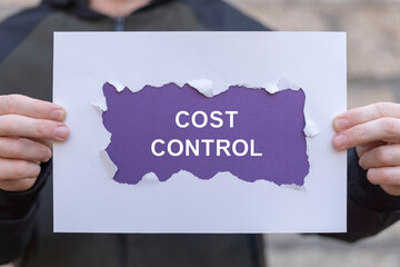 Person holding paper sheets banner sees the inscription: COST CONTROL. Cost and quality control, business strategy and project management concept. Cost reduction and effective enterprise.