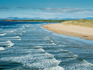 Powerful ocean waves and rich blue water of the ocean, Bundoran town, Ireland. Popular tourist area with stunning view and surfing area. Warm sunny day. Travel and tourism. Irish landscape.