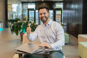 Young businessman closing laptop PC computer after finishing work good well done job in modern...