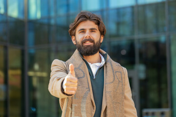 Like. Happy business man raises thumb up agrees with something or gives positive reply recommends...