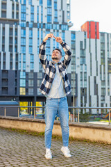 Middle-aged man tourist trying to catch a communication signal and Internet on mobile phone, raised...