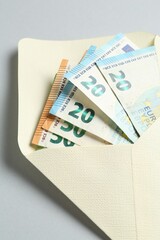 Money bonus. Envelope with euro banknotes on light grey background, closeup