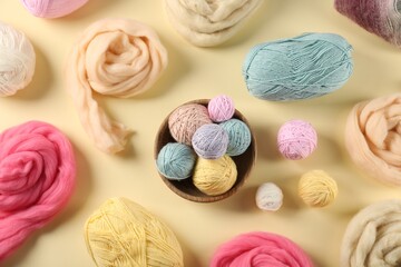 Felting wool and knitting yarn on beige background, flat lay