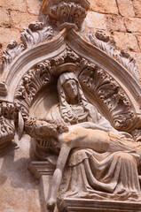 Baroque period sculpture of a "Pieta" on a church exterior wall in Dubrovnik, Croatia. The city's historical centre was extensively restored after the Balkan war.