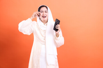 Heartbroken Hijabi: A Portrait of Digital Disappointment, showcasing modern emotions, and highlighting tech's impact in a relatable way, isolated on a orange background.