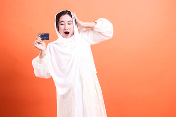 Excited Muslim Woman with Credit Card: A Moment of Joy and Financial Empowerment, isolated on a...