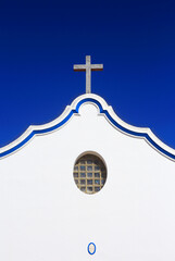 Alentejo, Portugal. Typical historic chapel with whitewashed walls, blue piping design and granite...