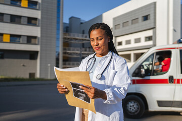 smile african american woman doctor hold baby sonogram image