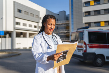 smile african american woman doctor hold baby sonogram image