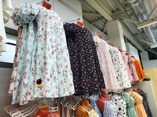 Beautiful summer bright stylish dresses hanging on a hanger show off a modern fashion collection....