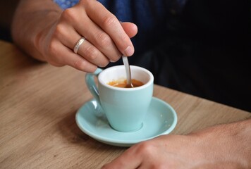 Man Stirring Espresso with Spoon