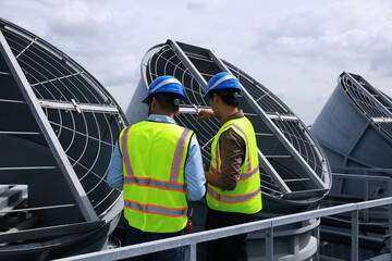 Mechanical engineer or industrial engineer with safety PPE inspect and maintenance cooling tower of...