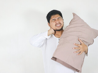 handsome asian man who just woke up showing a gesture of pain in the neck due to wrong sleeping...