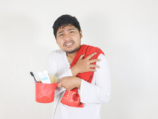 Handsome Asian man is going to take a bath and carrying toiletries placed on the ladle he is...