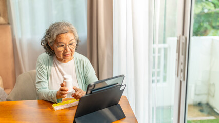 Asian senior woman video call with doctor on digital tablet consultation with medicine, drugs and supplements. Telemedicine, telehealth technology and medical healthcare in elderly people at home.