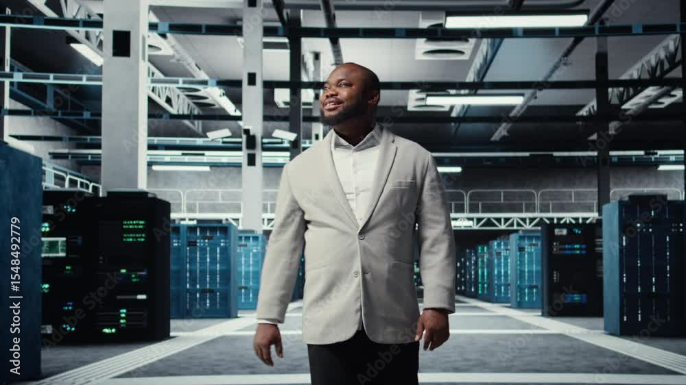 Poster smiling engineer walking in data center, checking hardware for system stability. happy employee over