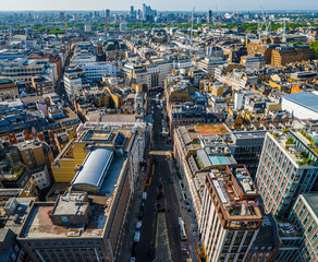 Aerial view of Oxford Circus in London with busy streets, iconic architecture, and red double-decker buses on a clear, sunny day