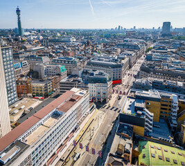 Aerial view of Oxford Circus in London with busy streets, iconic architecture, and red double-decker buses on a clear, sunny day