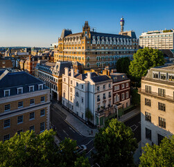 Aerial view of Cavendish Square Gardens in London surrounded by classic architecture, roads, and vehicles on a bright summer day.
