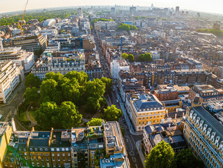 Aerial view of Oxford Circus in London with busy streets, iconic architecture, and red double-decker buses on a clear, sunny day