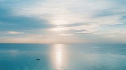 Obraz premium Calm expanse of ocean and sky at sunrise or sunset.