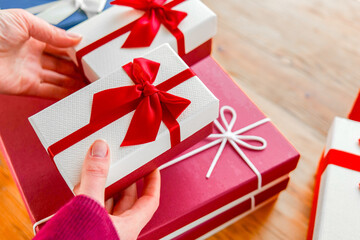 Mothers Day, Birthday, Christmas gifts and surprises. Wrapped Gifts with Ribbons on a Table.Person...