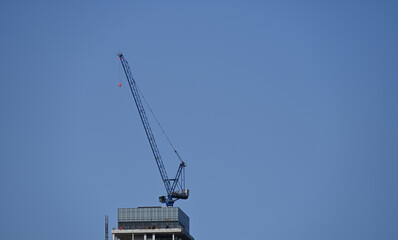 Naklejka premium tall construction crane against the sky