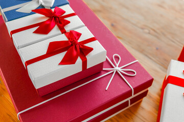 Colorful Wrapped Gifts with Ribbons on a Table.Gifts sets.Red and white boxes with bows. Mothers...