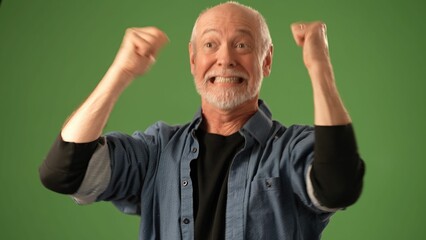 A mature man with gray hair shows excitement and happiness, raising his arms enthusiastically...